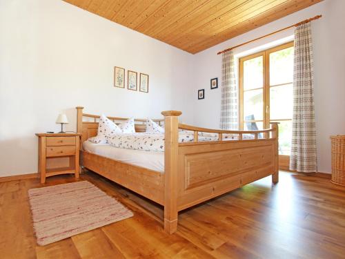 a bedroom with a wooden bed and a large window at Landhaus Albrecht in Mittenwald