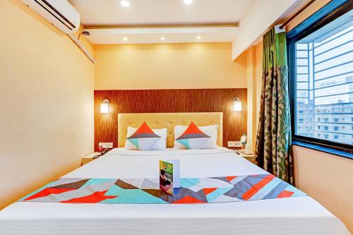 um quarto com uma cama grande e uma janela em FabExpress Step Inn em Calcutá