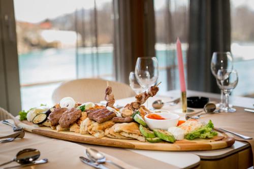 a plate of food on a table with wine glasses at Hotel Opal Exclusive Bihać in Bihać