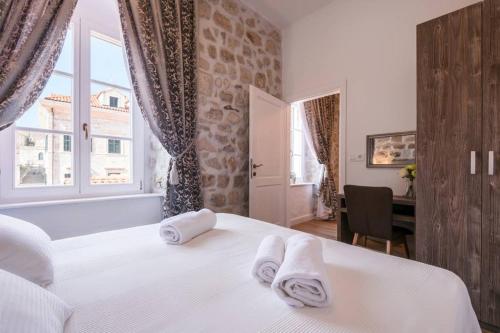 a bedroom with a white bed with towels on it at The Saint Blaise Luxury Collection in Dubrovnik
