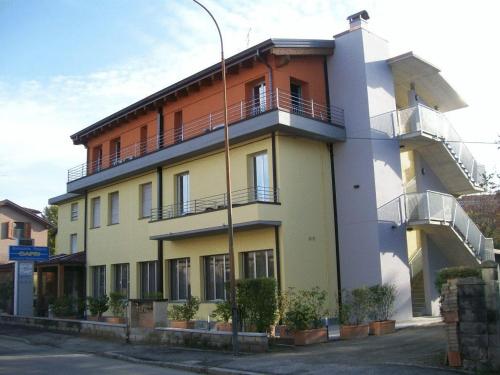 un edificio con balcones al costado de una calle en Hotel La Rosta, en Reggio Emilia