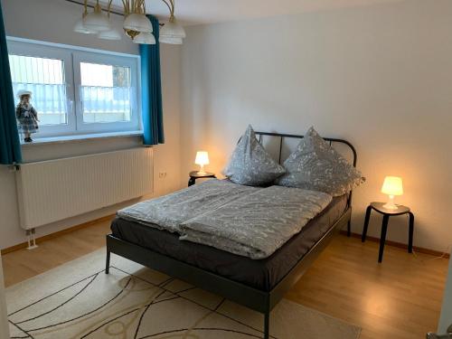 - une chambre avec un lit, deux lampes et une fenêtre dans l'établissement Ferienwohnung Stella, à Ichenhausen