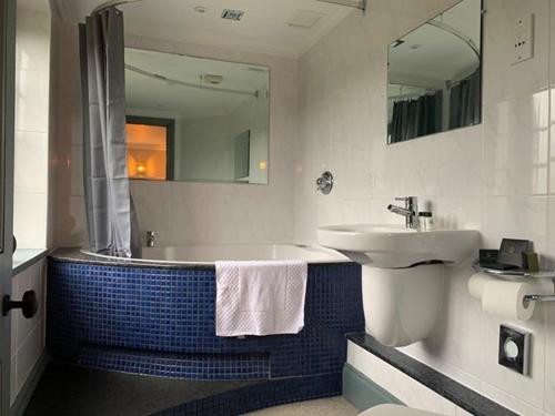 a bathroom with a sink and a bath tub with a sink at The Mooring Post in Gloucester