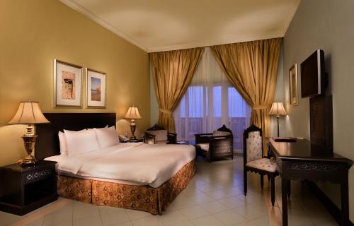 ḨilfにあるMasira Island Resortのベッドとデスクが備わるホテルルームです。