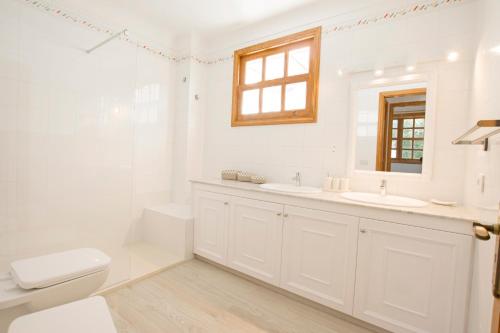 Baño blanco con 2 lavabos y aseo en Casa Betancuria, en San Bartolomé