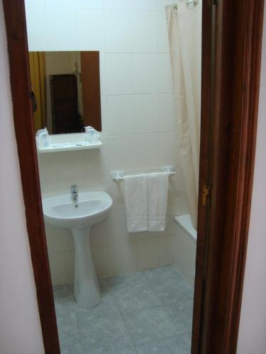 a bathroom with a sink and a toilet and a mirror at Hostal Durán in Alora