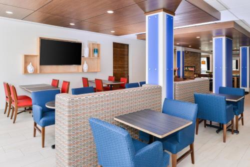 a restaurant with chairs and tables and a tv at Holiday Inn Express & Suites - Ogallala by IHG in Ogallala