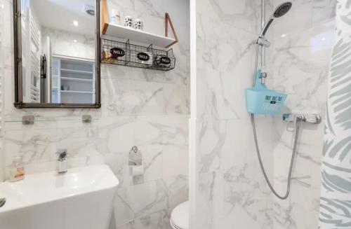 a white bathroom with a shower and a sink at CANNES Festival Films Center, with 2 bedrooms and balcony in Cannes