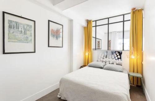 a white bedroom with a bed and a window at CANNES Festival Films Center, with 2 bedrooms and balcony in Cannes