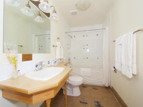 a white bathroom with a sink and a toilet at Best Maple Inn - Drayton Valley in Drayton Valley