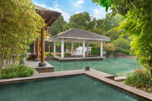 a swimming pool in a backyard with a gazebo at Holiday Inn Resort Chaohu Hot Spring, an IHG Hotel in Chaohu