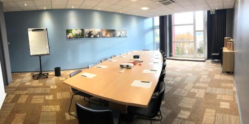 a large conference room with a long table and chairs at ibis Metz Nord in Woippy