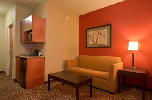 a hotel room with a couch and a table at Holiday Inn Express & Suites Pine Bluff/Pines Mall by IHG in Pine Bluff