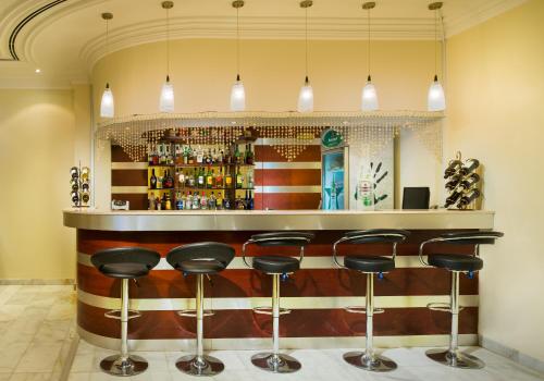 a bar with black stools in a room at Masira Island Resort in Ḩilf