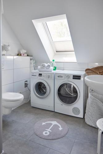 a bathroom with a toilet and a washer and dryer at Liegeplatz Appartements in Fockbek