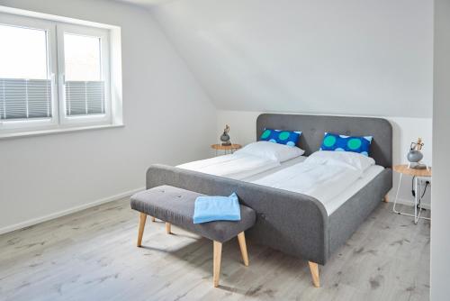 a bedroom with a large bed with blue pillows at Liegeplatz Appartements in Fockbek