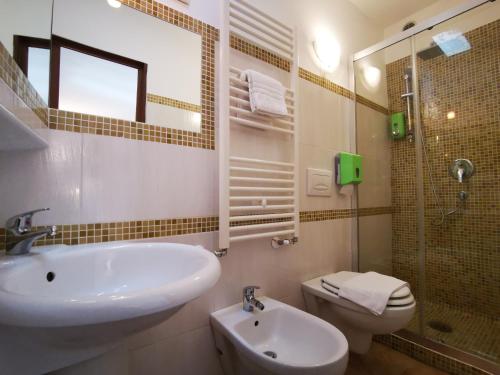 a bathroom with a sink and a toilet and a shower at Del Centro in Enna