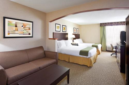 a hotel room with two beds and a couch at Holiday Inn Express Hotel & Suites Cleveland-Streetsboro by IHG in Streetsboro