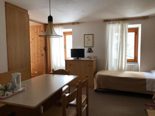 Zimmer mit einem Bett, einem Tisch und einem Bett mit einem sidx sidx sidx in der Unterkunft B&B Monte Giove Formazza in Formazza