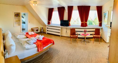 a bedroom with a large bed with red curtains at Aparthotel Kleine Perle in Cuxhaven