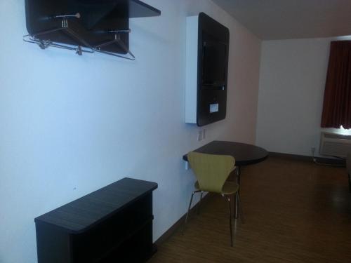 a room with a table and a tv on the wall at Motel 6 Bell Gardens, CA - Los Angeles in Bell Gardens