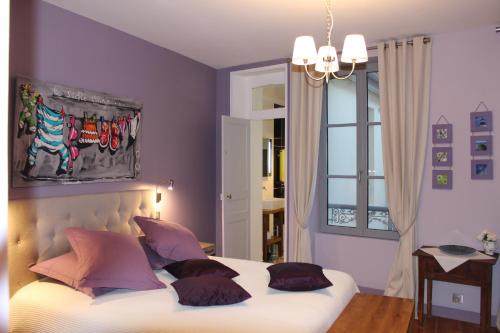 a bedroom with a bed with pillows on it at La Maison de Juliette in Granville