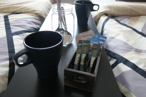 a black table with books and cups on a bed at WEST WOOD GUEST ROOM in Osaka