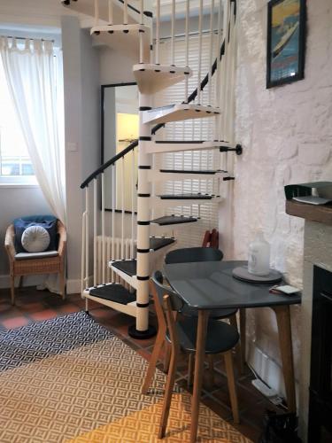 a dining room with a table and a spiral staircase at Heritage City - The Auld Pottery in Edinburgh