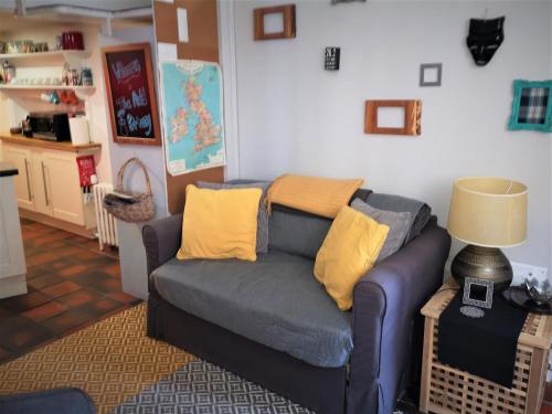 ein Wohnzimmer mit einem blauen Sofa und gelben Kissen in der Unterkunft Heritage City - The Auld Pottery in Edinburgh