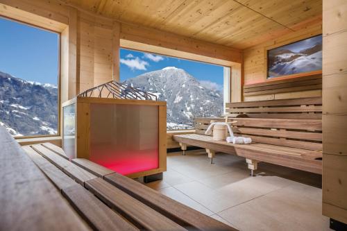 a room with benches and a view of a mountain at Alpin Family Resort Seetal in Kaltenbach