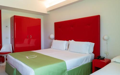 a hotel room with two beds with red headboards at Domina Zagarella Sicily in Santa Flavia
