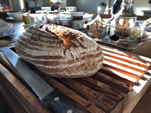 a loaf of bread sitting on a table with a knife at Ellesmere House in Castle Cary