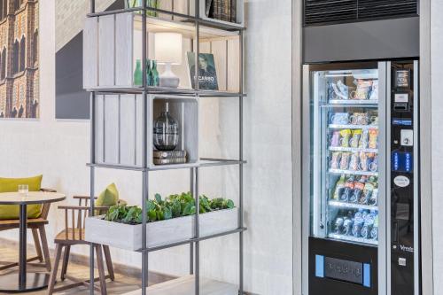 a shelf with plants in it next to a refrigerator at IntercityHotel Saarbrücken in Saarbrücken