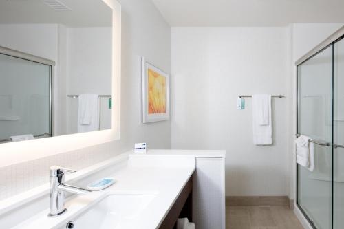 uma casa de banho branca com um lavatório e um espelho em Holiday Inn Express East Peoria - Riverfront, an IHG Hotel em Peoria