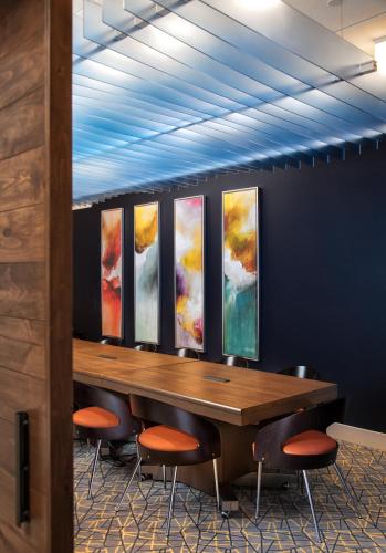 a conference room with a table and four paintings on the wall at Holiday Inn Express East Peoria - Riverfront by IHG in Peoria