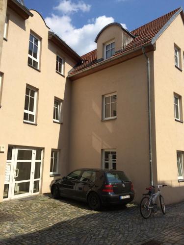 a car parked in front of a building at FEWO am Markt in Neustadt in Sachsen