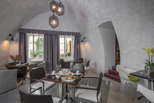 a dining room with tables and chairs and a window at Monastery Garden Prague in Prague
