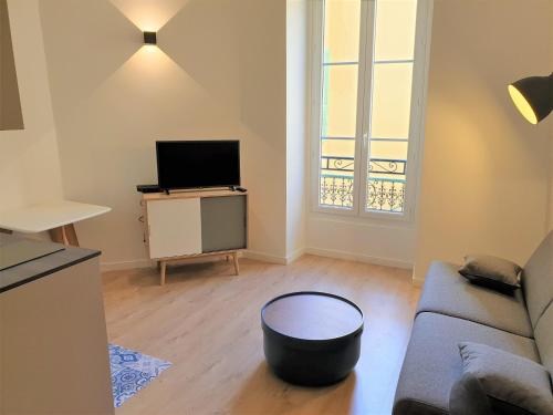 un salon avec un canapé et une télévision dans l'établissement STUDIO HYPERCENTRE-101, à Nice