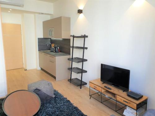 un salon avec une télévision à écran plat et une table dans l'établissement STUDIO HYPERCENTRE-405, à Nice