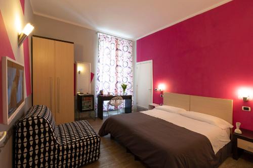 Un dormitorio con una cama grande y una pared rosa en H Rooms boutique Hotel, en Nápoles