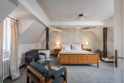a hotel room with a bed and two chairs at Monastery Garden Prague in Prague