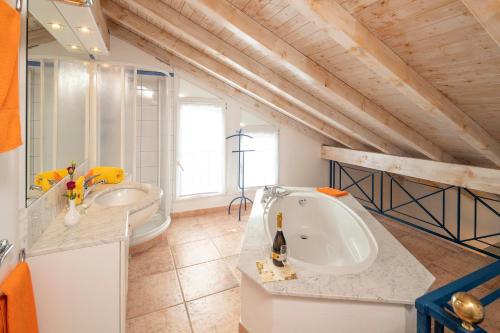 łazienka z 2 umywalkami i wanną w obiekcie Hotel al Ponte Antico w mieście Intragna