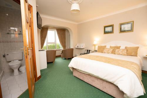 a hotel room with a bed and a bathroom at Arches Country House in Donegal