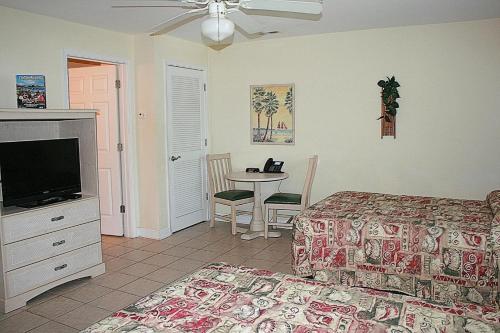 1 dormitorio con 1 cama, TV y mesa en Brunswick Plantation Resort 2705L, en Calabash