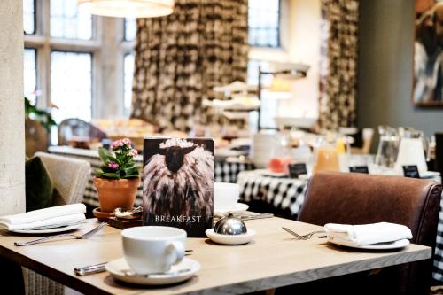 a table in a restaurant with a book on it at The Lamb Inn in Burford