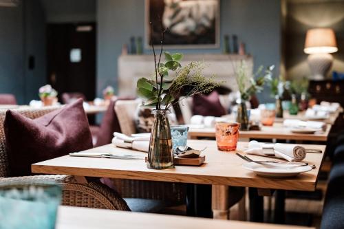 a wooden table with a vase of flowers on it at The Lamb Inn in Burford