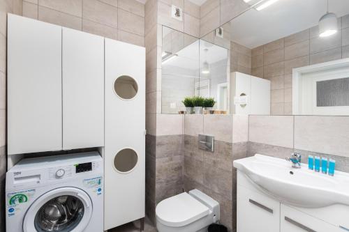 a bathroom with a washer and a sink and a washing machine at Rakowska 14A 1 bedroom by Homeprime in Warsaw