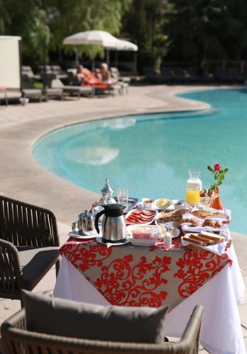 a table with food on it next to a swimming pool at Kenzi Club Agdal Medina - All Inclusive in Marrakesh