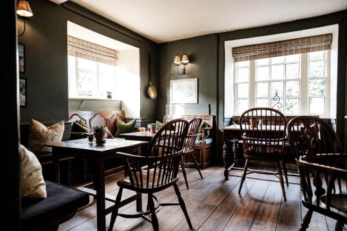 - un salon avec une table, des chaises et un canapé dans l'établissement The Lamb Inn, à Burford