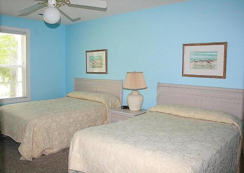 Duas camas num quarto com paredes azuis em 1404 villa em Calabash